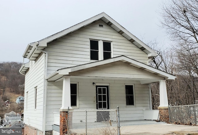 view of front of property with a porch and fence