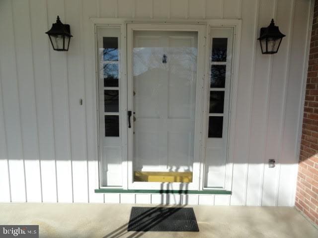 entrance to property with brick siding and board and batten siding