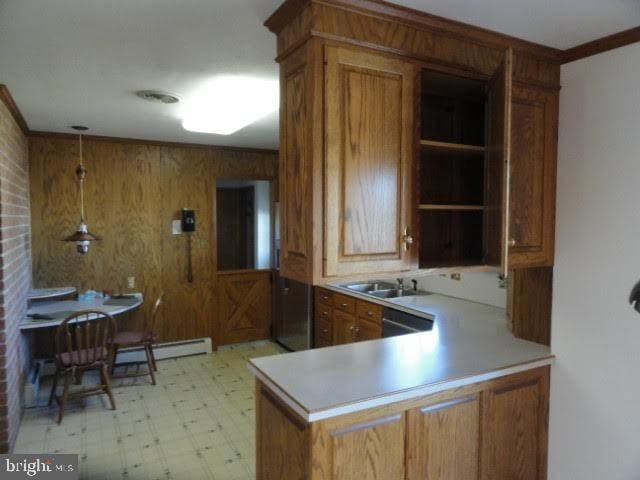 kitchen featuring light floors, brown cabinets, and a sink