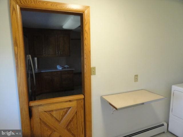 laundry room featuring baseboard heating and washer / clothes dryer