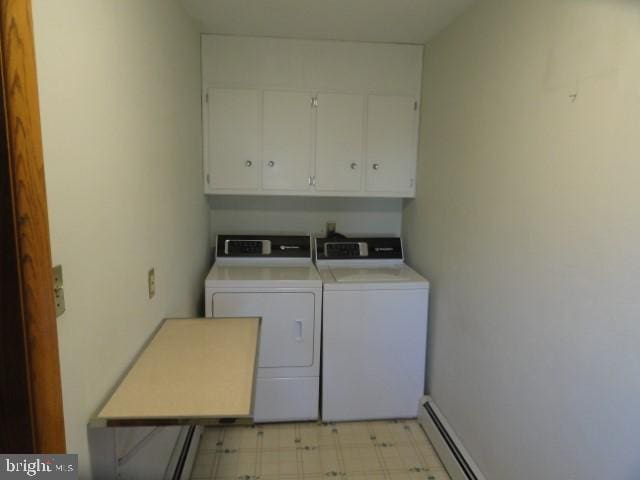 washroom featuring cabinet space, independent washer and dryer, light floors, and a baseboard radiator