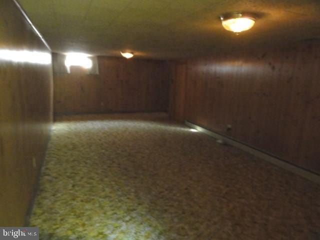 finished basement featuring wooden walls and carpet