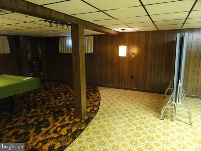 finished below grade area with tile patterned floors, a paneled ceiling, wooden walls, and billiards