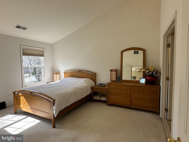 bedroom with lofted ceiling, visible vents, and light carpet