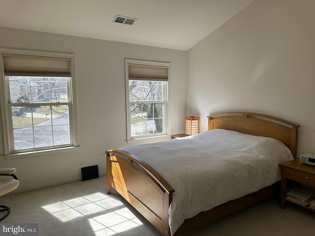 carpeted bedroom featuring visible vents, multiple windows, and lofted ceiling