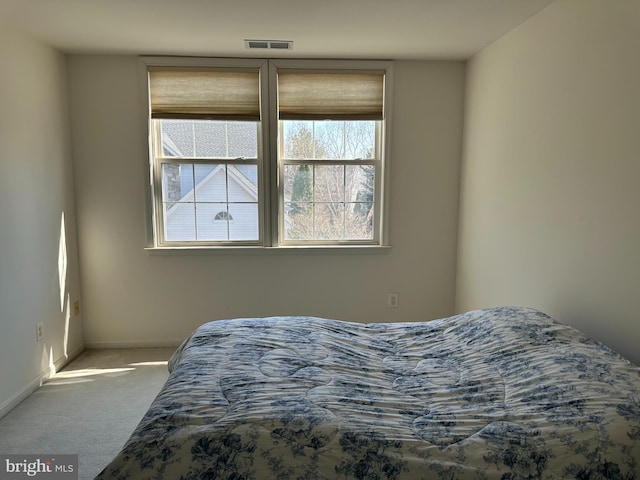 carpeted bedroom with visible vents and baseboards