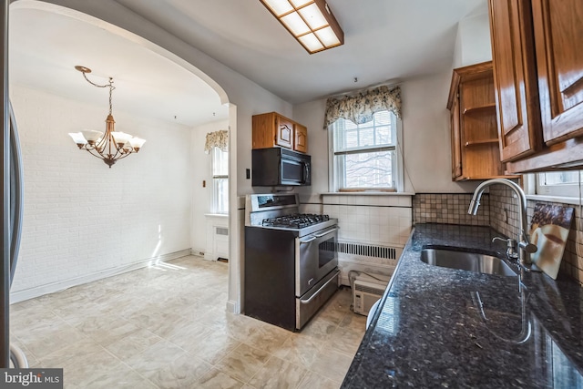 kitchen with stainless steel gas range oven, open shelves, a sink, arched walkways, and black microwave