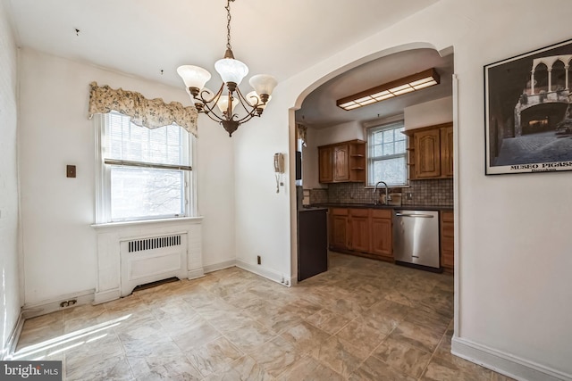 kitchen with open shelves, an inviting chandelier, dark countertops, arched walkways, and dishwasher