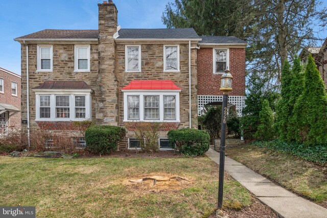 multi unit property with a chimney, a shingled roof, and a front lawn