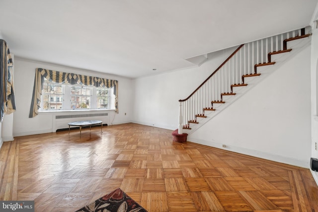 interior space featuring baseboards, stairs, and radiator