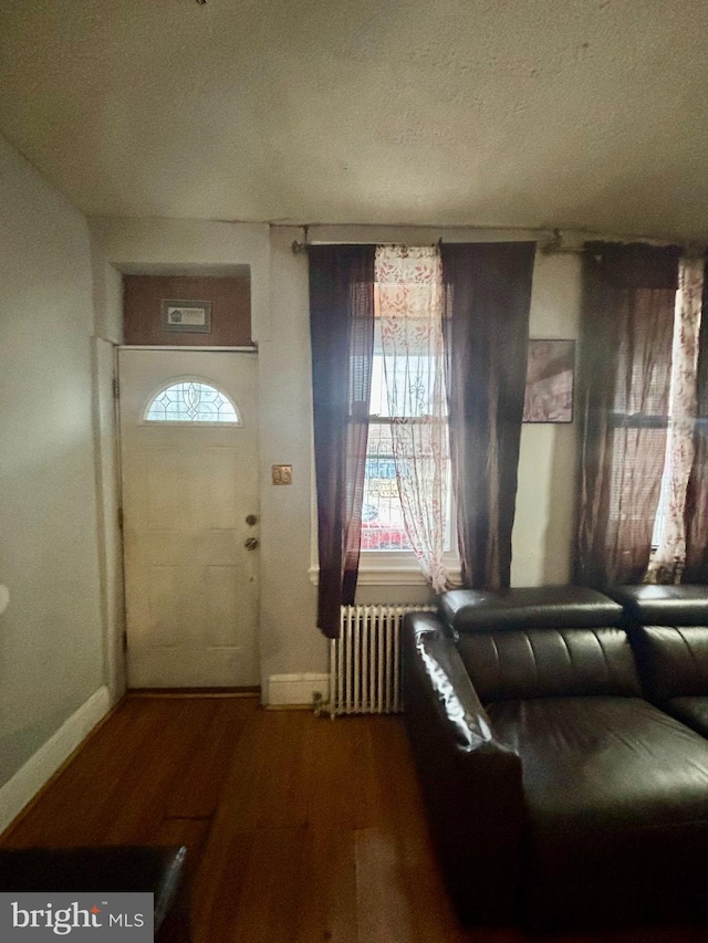 3316 Jasper St, Philadelphia, PA 19134 - foyer with a textured ceiling, radiator heating unit, baseboards, and wood finished floors