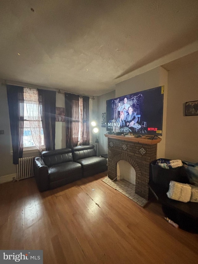 3316 Jasper St, Philadelphia, PA 19134 - unfurnished living room featuring radiator, wood finished floors, and a textured ceiling