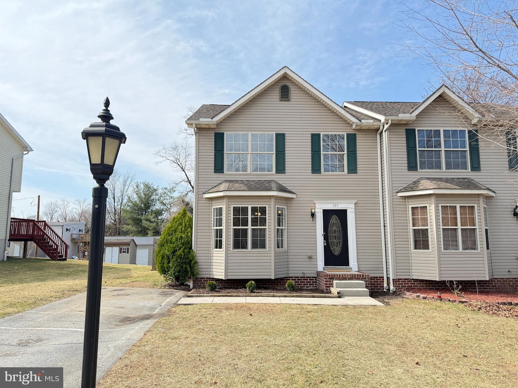 traditional home with a front yard and entry steps