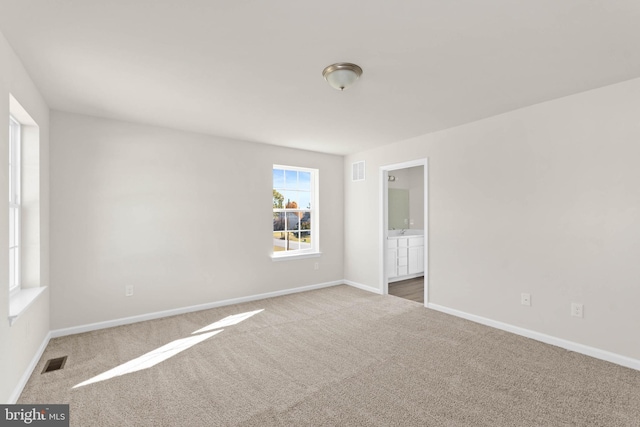 empty room featuring visible vents, baseboards, and carpet