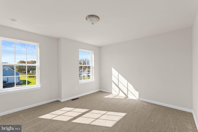 carpeted empty room featuring visible vents and baseboards