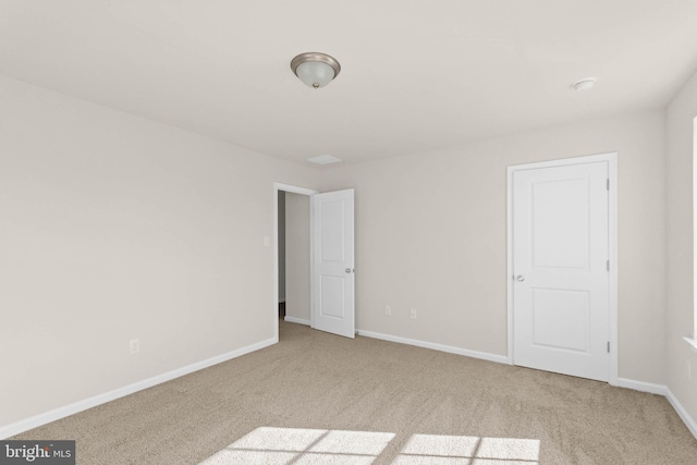 carpeted spare room featuring baseboards