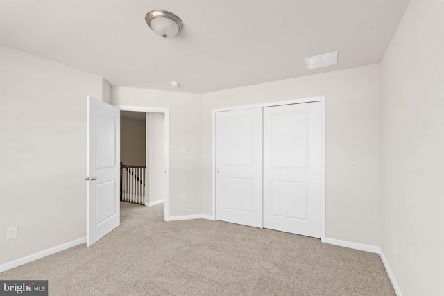 unfurnished bedroom with a closet, visible vents, baseboards, and carpet