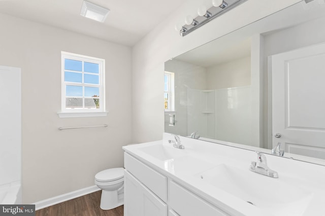 bathroom featuring a sink, toilet, a healthy amount of sunlight, and wood finished floors