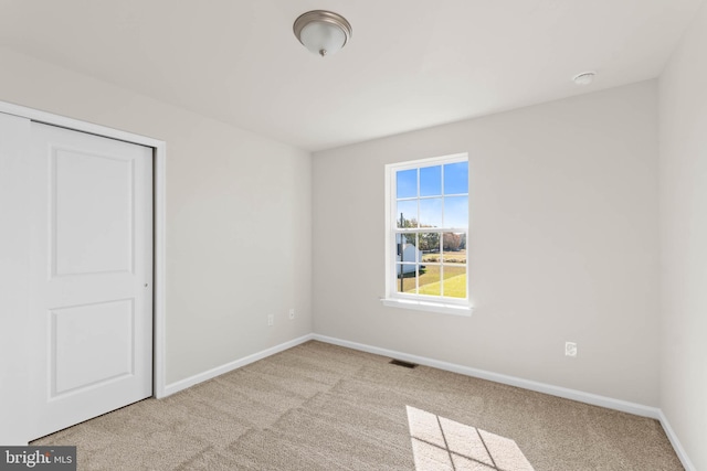 carpeted empty room with baseboards and visible vents