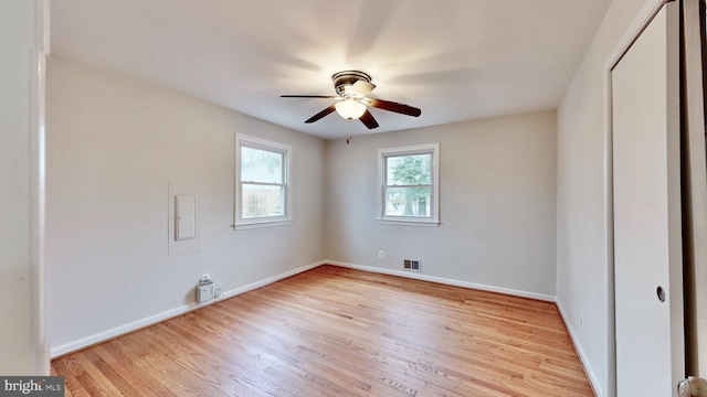 unfurnished bedroom featuring visible vents, baseboards, a closet, and wood finished floors