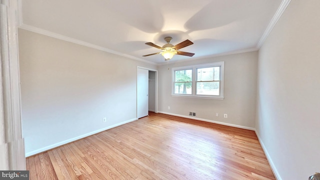 unfurnished room featuring ornamental molding, ceiling fan, baseboards, and wood finished floors