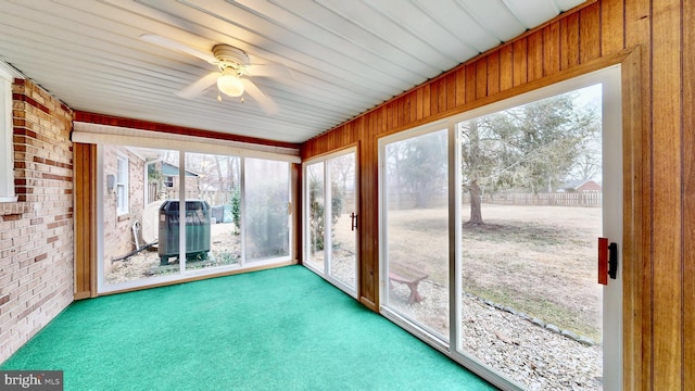 unfurnished sunroom with a ceiling fan