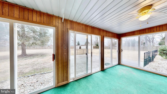 unfurnished sunroom featuring a wealth of natural light and a ceiling fan