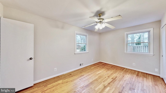 unfurnished room with visible vents, baseboards, a ceiling fan, and hardwood / wood-style flooring