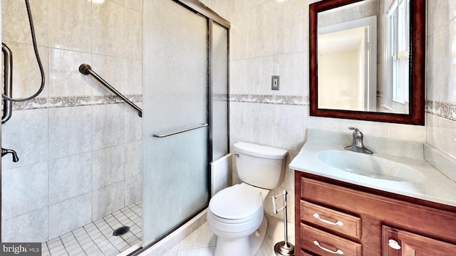 full bath featuring tile walls, a stall shower, and vanity