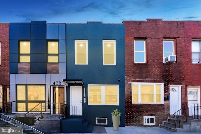 multi unit property featuring entry steps, cooling unit, and brick siding