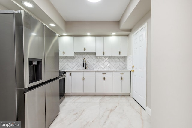 kitchen with marble finish floor, stainless steel refrigerator with ice dispenser, a sink, light countertops, and range