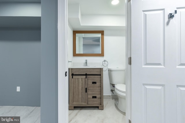 bathroom with marble finish floor, toilet, and vanity