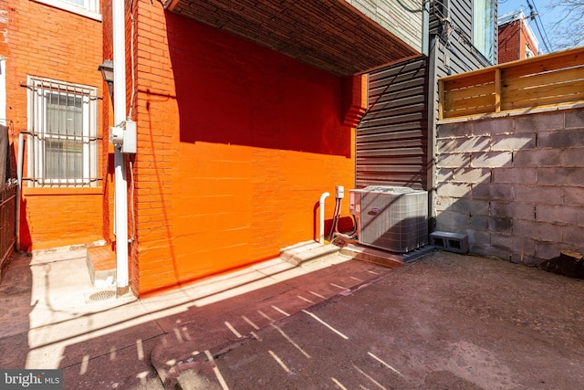 view of property exterior featuring brick siding and central AC