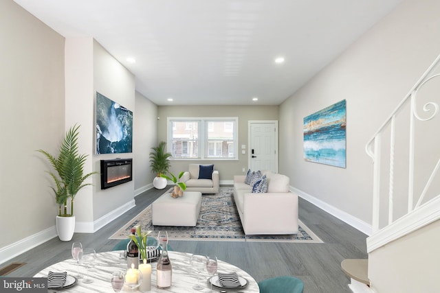 living room featuring visible vents, baseboards, and a glass covered fireplace