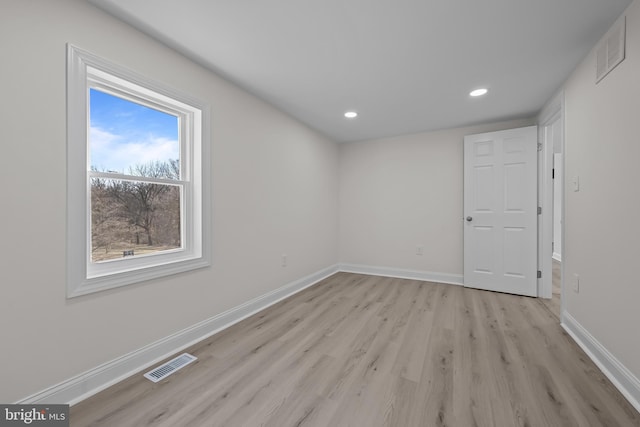 empty room with visible vents, baseboards, and light wood finished floors