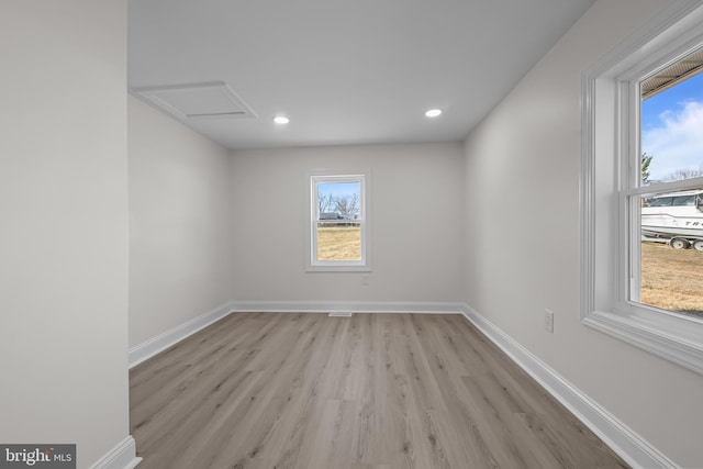 spare room with attic access, recessed lighting, baseboards, and light wood-type flooring