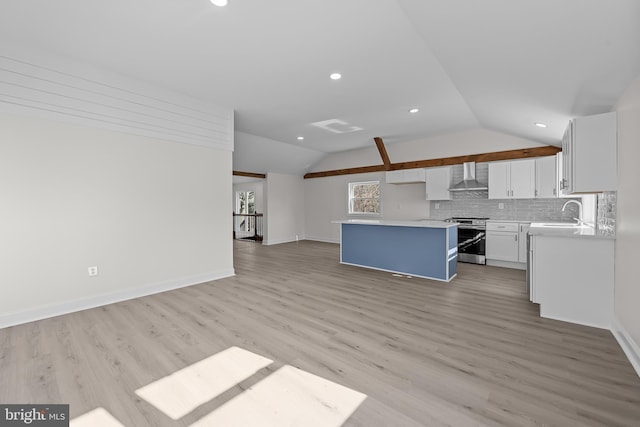 kitchen with a kitchen island, wall chimney range hood, lofted ceiling, decorative backsplash, and stainless steel range with electric cooktop