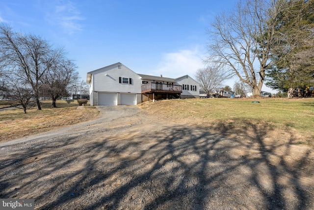 view of side of home featuring a yard, a deck, a garage, and dirt driveway