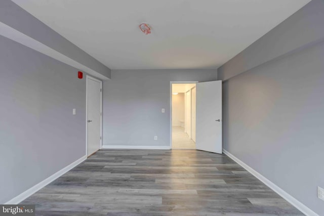 spare room featuring baseboards and wood finished floors