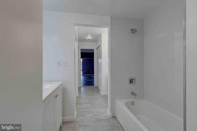 full bath with vanity,  shower combination, and baseboards