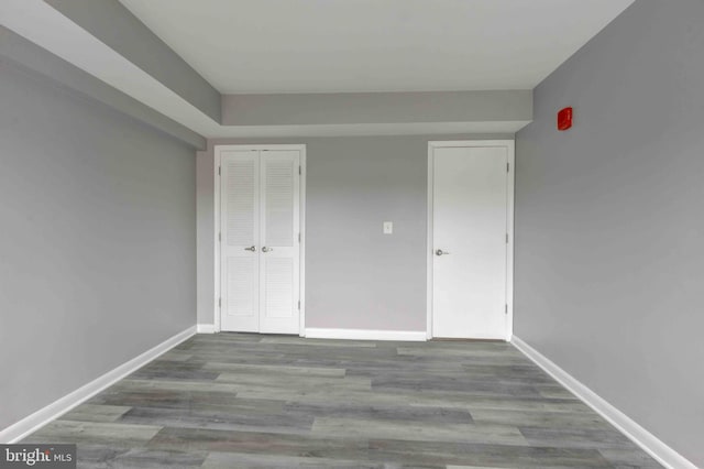 unfurnished room with baseboards and wood finished floors