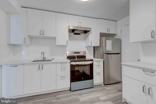 kitchen featuring under cabinet range hood, light countertops, appliances with stainless steel finishes, and a sink