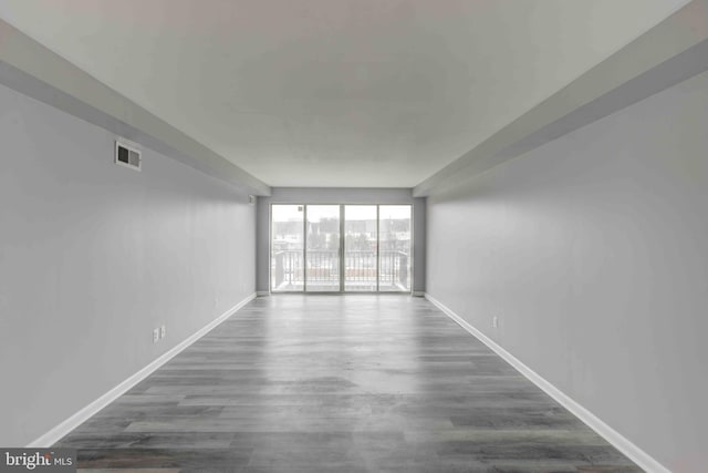 unfurnished room featuring dark wood finished floors, baseboards, and visible vents