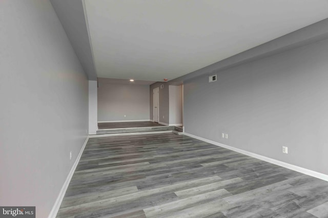 spare room with visible vents, baseboards, and wood finished floors