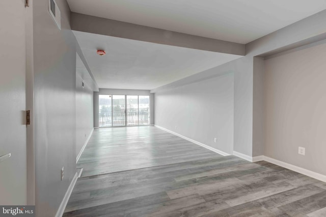 spare room featuring visible vents, wood finished floors, and baseboards