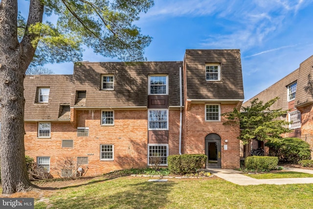 view of front of property with a front lawn and brick siding