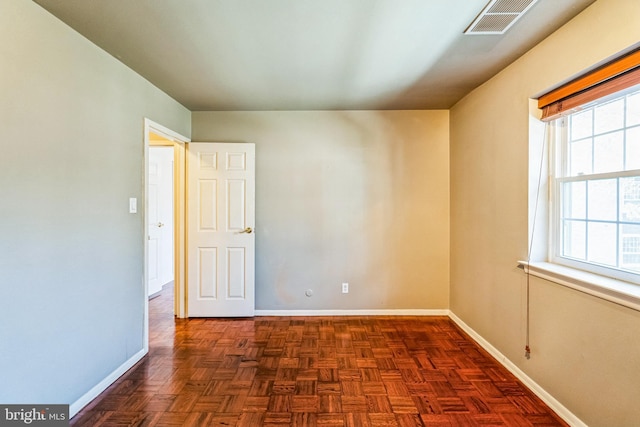 spare room with baseboards and visible vents