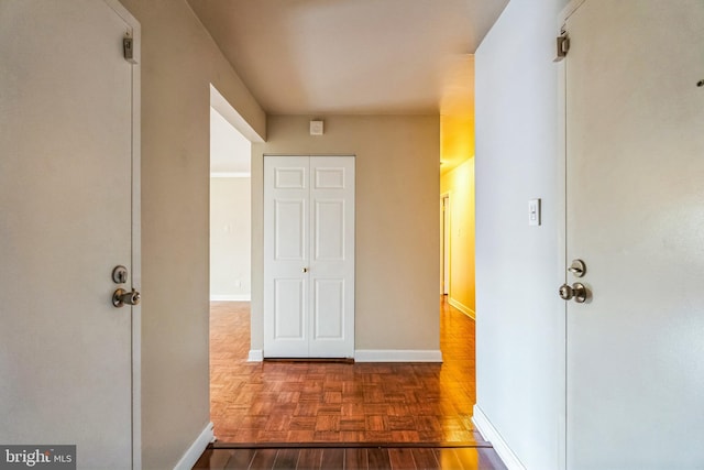 hallway with parquet floors and baseboards