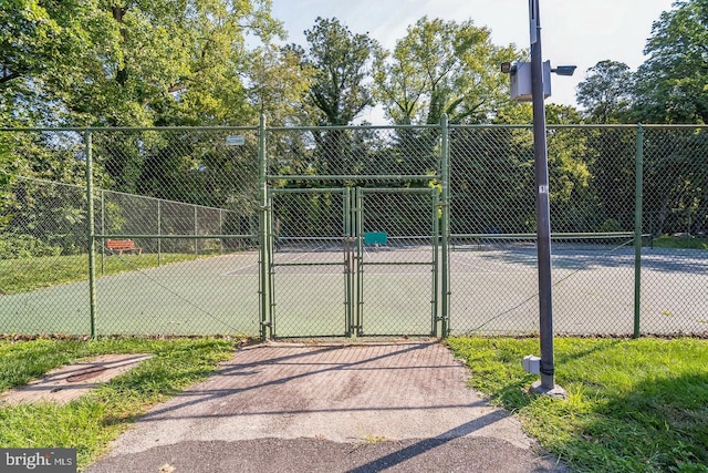 view of sport court with fence and a gate