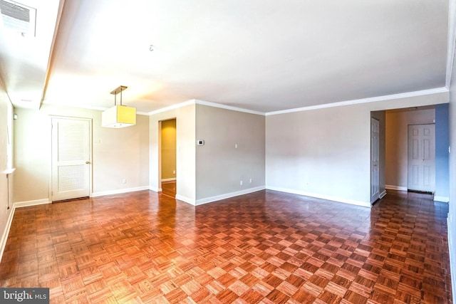 empty room featuring visible vents, crown molding, and baseboards